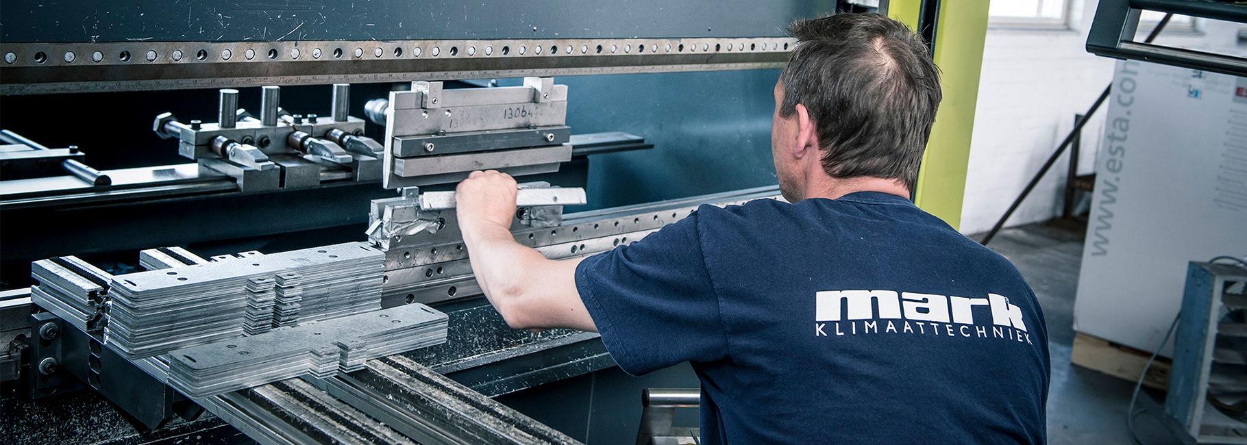 Een productiemedewerker van Mark Climate Technology achter de kantbank